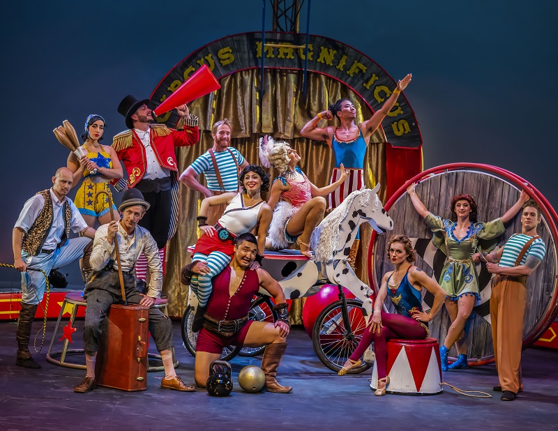 Circus performers pose for a group photo on stage