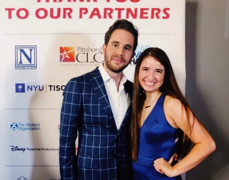 Teen girl in a blue dress poses with Ben Platt, wearing a gray blazer