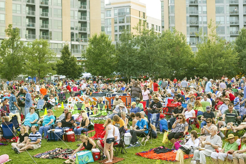 A crowd of people gathers in a park