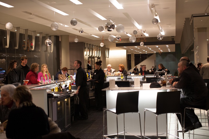 Patrons stand and socialize at a busy bar