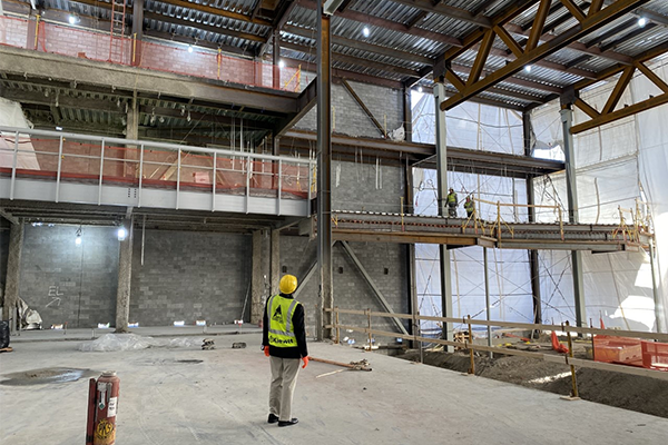 Person in hard hat surveys inside progress of Steelhouse Omaha